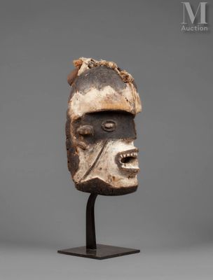 a wooden mask on a stand with a gray background