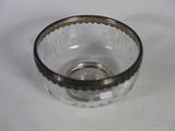 a small glass bowl with a silver rim on a table