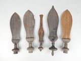 four wooden knives are lined up against a white wall