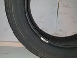 tire on the floor of a garage with a white wall in the background