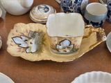 a table with a tea pot and cups and saucers on it