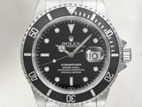 a close up of a watch with a black dial on a bracelet