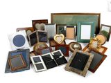 une pile de cadres photo de toutes sortes posés sur une surface blanche