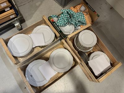 quatre cartons d'assiettes vides au milieu du sol