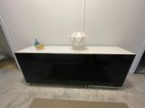 une armoire noire et blanche sur laquelle est posé un vase
