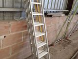 a ladder leaning against a wall next to a brick wall