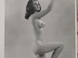 black and white photograph of a naked woman holding a globe