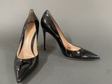 a pair of black high heels on a grey surface