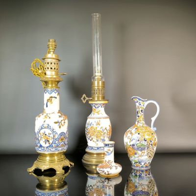 three vases and a lamp on a table
