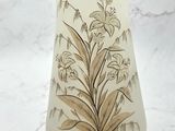un vase blanc orné d'un motif floral