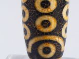 a black and white vase with yellow and black designs on it