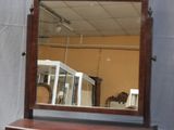 un miroir posé sur une commode, à côté d'un autre miroir