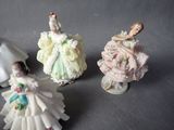three porcelain figurines of women in dresses and dresses on a table
