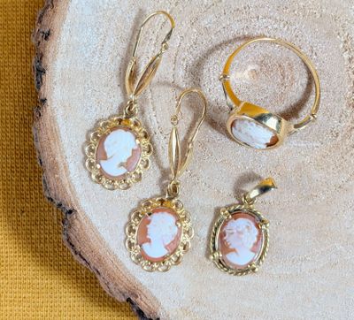 deux paires de boucles d'oreilles et une bague sont posées sur un morceau de bois