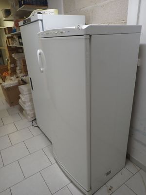 un réfrigérateur blanc posé dans le coin d'une pièce
