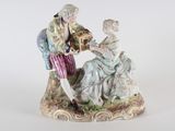 une figurine représentant un homme et une femme assis sur un banc