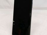 a black cell phone sitting on a stand on a white surface