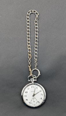 une montre de poche attachée à une chaîne, posée sur une surface grise