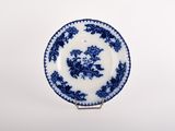 a close up of a blue and white plate with flowers on it