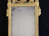a gold mirror with a bird on it and a black background