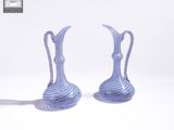 une paire de vases rayés bleus et blancs posés sur une surface blanche