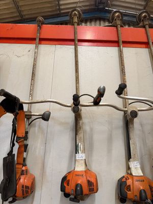 Plusieurs outils électriques sont accrochés au mur d'un garage.