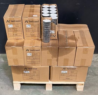 des cartons empilés les uns sur les autres sur une palette devant un mur noir