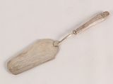 a silver spoon with a handle on a white surface