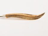 gold feather hair clip on a white background