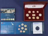 une boîte de pièces et un livret posés sur une table