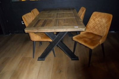 une table en bois entourée de quatre chaises, posée sur un parquet en bois dur