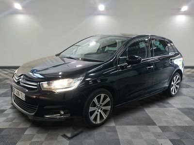 la voiture noire est garée sur un sol en damier dans le garage
