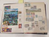 un livre ouvert sur lequel sont posées des photos et des cartes postales