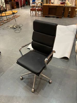a black office chair and a black chair in the middle of a room