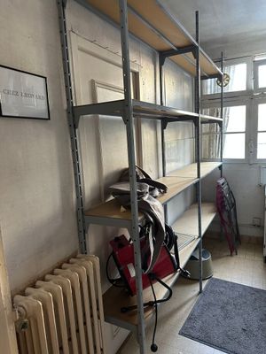 a room with a radiator, bookshelf, and other items in it