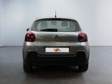 the rear of a silver car is parked in a white room