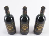 three bottles of wine sitting next to each other on a white surface
