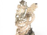 carved ivory figurine of a woman and a bird on a rock