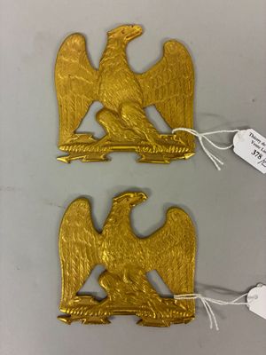 two gold eagle badges on a white background with a price tag