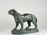 bronze statue of a lion on a rock on a white background