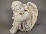 a statue of an angel sitting on a rock