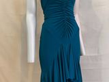 Le mannequin porte une robe vert sarcelle à volants.