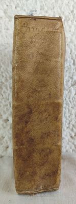a brown book sitting on a table with a white wall in the background