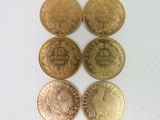 six pièces de monnaie britanniques différentes posées sur une surface blanche