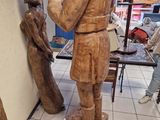 une statue en bois représentant un homme tenant un enfant dans ses bras