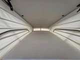 underside view of a white tent with black handles on a sunny day