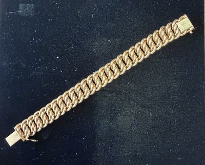 a close up of a gold chain bracelet on a black surface