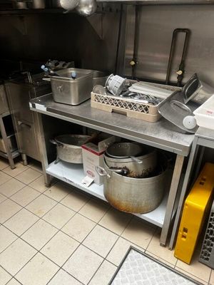 une cuisine avec beaucoup de casseroles et de poêles sur le comptoir