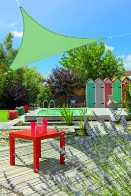 une table rouge posée sur une terrasse en bois près d'une piscine