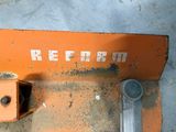 a rusted orange sign on the side of a building